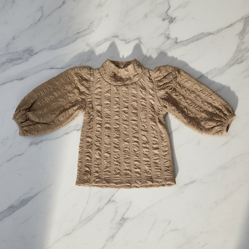Girl's top featuring a floral jacquard pattern and lantern sleeves.