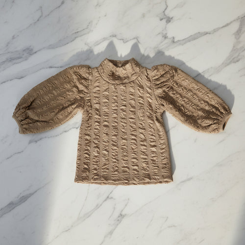 Girl's top featuring a floral jacquard pattern and lantern sleeves.